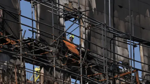 PA Media A firefighter at the scene in Dagenham