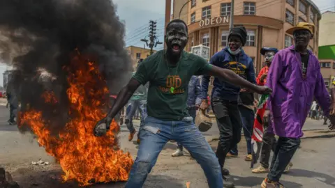 Getty Images Demonstrators, gathering in the city center, make a fire as they march towards the parliament building to protest the 'Finance Bill 202