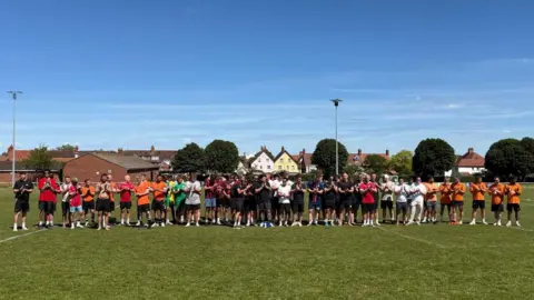 Freddie Pring Memorial Fund A group of people is standing next to each other on a football pitch.