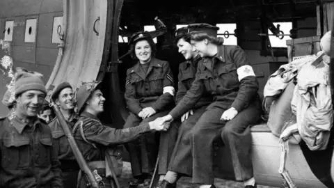 Ministry of Defence  Lydia Alford (L), Leading Aircraftwoman Myra Roberts (C) and Edna Birkbeck (R), are greeted are greeted on their arrival in Normandy 