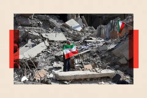 AFP via Getty Images A man holds an Iranian flag amid the debris of a destroyed building following airstrikes in central Tehran 