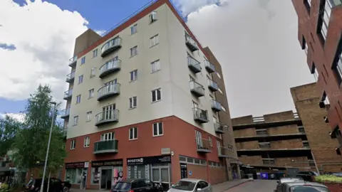 A Google Maps picture of Gowring House, a six-storey flat building in Bracknell, with other buildings nearby.