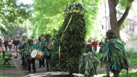 Bristol Jack in the Green A large green structure with a person inside it, known as Jack in the Green, is seen as part of a procession heading through a green space in the city centre. The other people in the procession are covered in green leaf-like clothing and some are playing drums