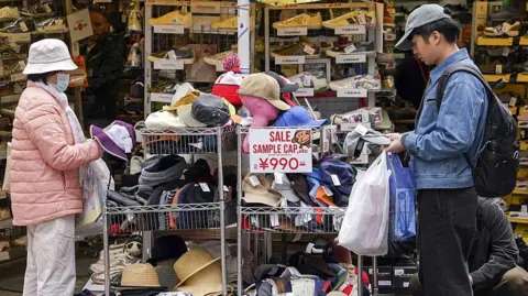 Shoppers look at hats at a store in the Ueno area in Tokyo.