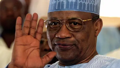 General Ibrahim Badamasi Babangida of Nigeria, wearing glasses and a blue hat