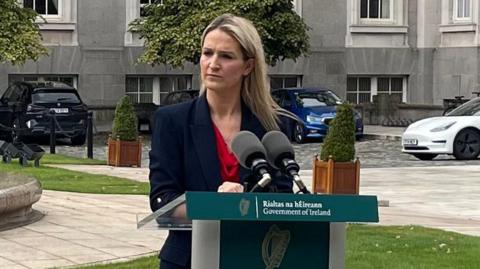 Justice Minister Helen McEntee at podium in front of Government Buildings in Dublin