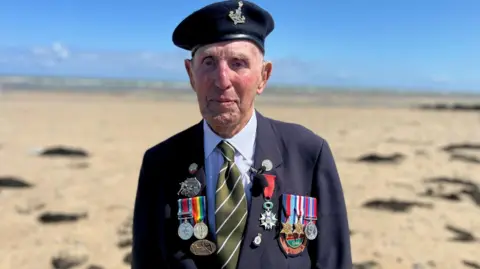 Olivia Richwald/BBC An old man wears a beret with insignia and a jackt festooned with medals