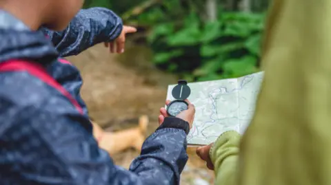 Girls read a map with a compass