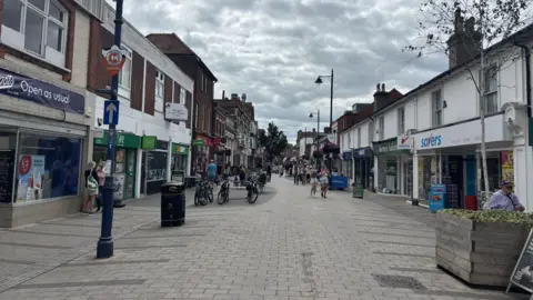 A street view of the high street in Felixstowe. There are shops down either side and the central area is just pedestrianised 
