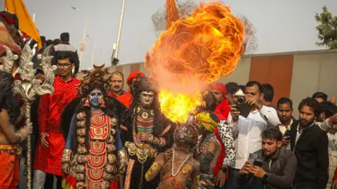 Devotees of Ankit Srinivas perform fire rituals as they enter the festival