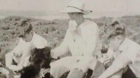 Hoburne Holiday Parks A woman, two boys and a dog, eating sandwiches by the coast in 1937. 