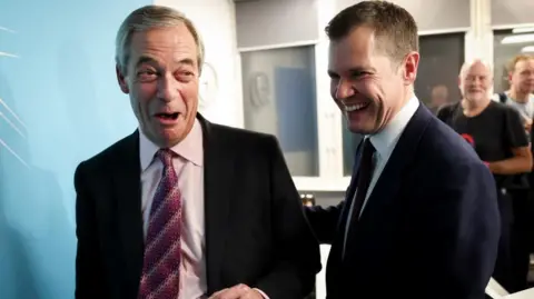Former British Conservative Party member Robert Jenrick with Reform UK leader Nigel Farage at a press conference, as Jenrick has announced he has defected from the country's Conservative Party to the right-wing Reform UK Party, in London, January 15, 2026.