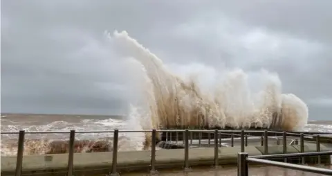 BBC Weather Watchers / Clare Waves crash into the seafront in Devon on Saturday. Lots of spray and foam around the railings 