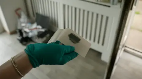 A tool cast being held up by a person in a green glove.