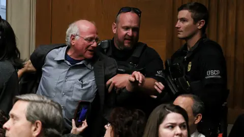 Image shows Ben Cohen, co-founder of ice cream company Ben & Jerry’s, being removed by US Capitol Police at a Senate Health, Education, Labor & Pensions Committee hearing in Washington, DC, on 14 May, 2025
