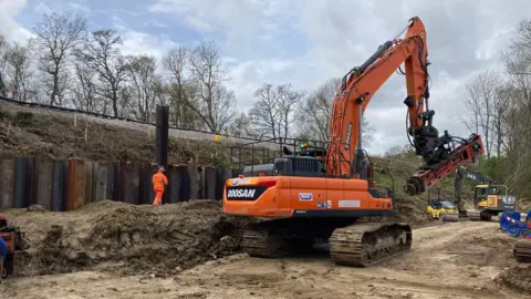 BBC/Piers Hopkirk A crane installing steel piles to stabilise the Bough Beech embankment