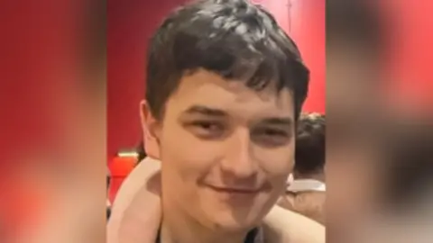 Susan Dingle Tom is photographed smiling. It is a close up photograph.