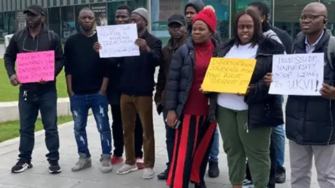 A group of Teesside University students holding placards