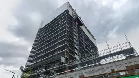 A tower block covered in scaffolding