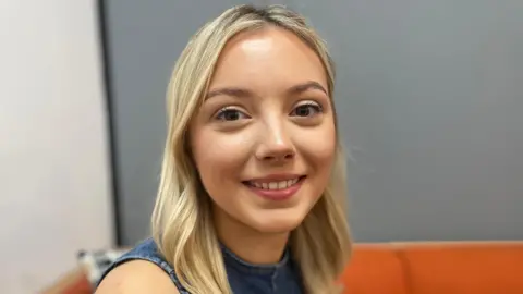 Arwen, with long blonde hair, smiles at the camera