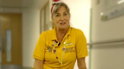 Volunteer Penny Pritchard in a yellow Great Ormond Street Hospital t-shirt.