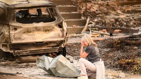 A woman cries amid the burnt rubble in Spokane, Washington