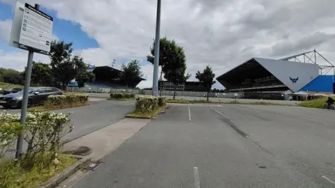 OXFORD UNITED FANS PAGE ON FACEBOOK Kassam Stadium car park with new sign in foreground