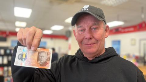 Person holding up a new £10 bank note
