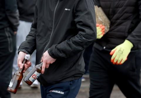 A group of young men carrying petrol bombs and stones at the start of an Easter Monday parade in the Creggan area of Londonderry