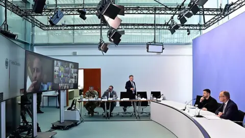 Getty Images Presidente ucraniano Volodymyr Zelensky y el canciller alemán Friedrich Merz enfrentan una pantalla durante una videoconferencia de líderes europeos con el presidente de los Estados Unidos en la guerra de Ucrania antes de la cumbre entre los líderes estadounidenses y rusos