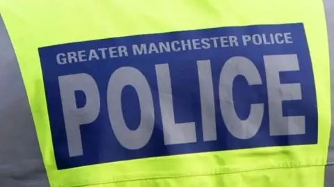 The back of a Greater Manchester Police officer high visibility illuminated green vest 