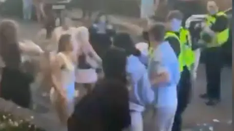 Curtis Henderson A blurred image taken from a video of a group of teenagers clashing with police. 