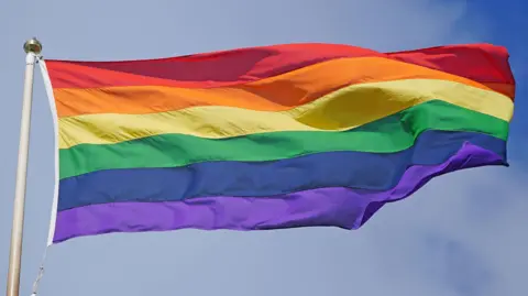 A Pride flag. It is a rainbow flag made up of six horizontal stripes which are all different colours.