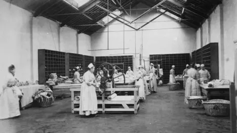 A black and white image of women doing work in one of the wings at the prison.