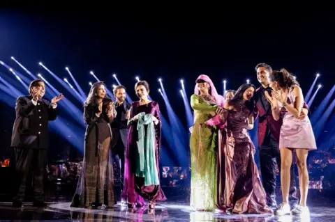 Reuters Mukesh Ambani, the Chairman of Reliance Industries, Radhika Merchant, Anant Ambani, Nita Ambani, Rihanna, Isha Piramal, Anand Piramal, Shloka Mehta Ambani and Akash Ambani react during pre-wedding celebrations of Anant and Radhika in Jamnagar, Gujarat, India, March 1, 2024