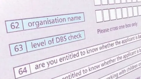 A still image of an online DBS form. The words 'level of DBS check' are visible. The form is coloured shades of blue and purple. 