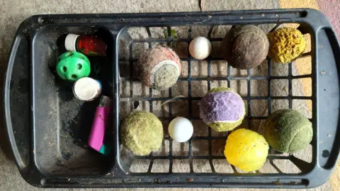 Colin Smith A basket with a few colourful - if faded and slightly worse for wear - tennis balls in it.
