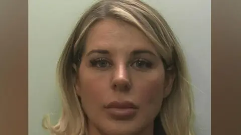 Devon and Cornwall Police Mugshot of a blonde woman who is staring straight into the camera.