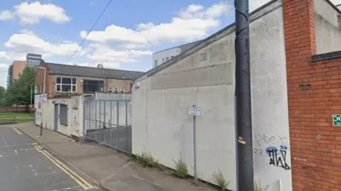 Graffiti on a wall with a grey gate in the middle of the image