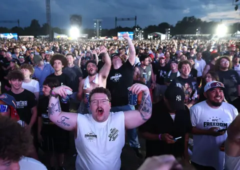 Getty Images A crowd of men cheer while watching a UFC event