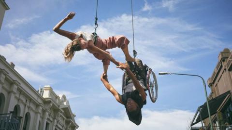 Disabled performers hang in the air during street performance
