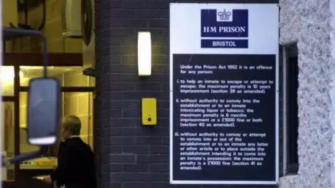 PA Media Bristol prison. The image shows an entrance, with a prison officer in the background, next to a sign explaining the Prison Act 1952.