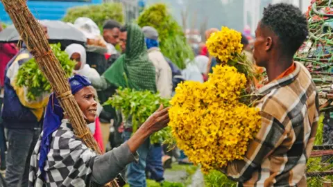 अमेन्सीसा आयएफए/बीबीसी इथिओपिया अ‍ॅडिस अबाबा फ्लॉवर विक्रेता फ्लॉवर विक्रेता एक महिला पिवळ्या फुलांची एक महिला - बुधवार 10 सप्टेंबर