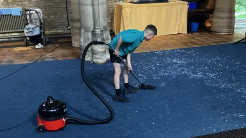 Supplied Boy with vacuum cleaner
