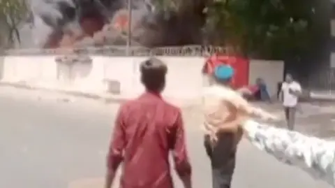 PTI Vishwash Kumar Ramesh seen emerging from the crash site and Satinder Singh Sandhu guiding him to safety