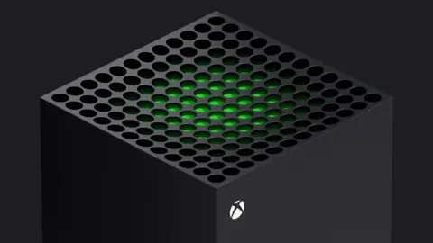 Microsoft The top of a cuboid shaped Xbox One console is seen against a dark background. A green glow emanates from the circular holes on top of the machine, and a small white circle with an X inside it is printed on the side.