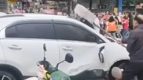 A man attacks the white SUV that ran into a crowd outside the school