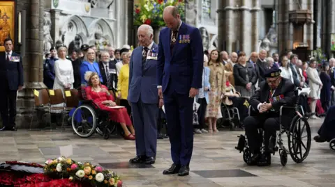 VE Day service honours last generation of WW2 veterans 8 Reuters The Prince of Wales and King Charles stand in suits, wearing medals, beside a World War Two veteran in a wheelchair, as they all bow their heads at the grave of the Unknown Warrior after laying wreaths during a service of thanksgiving at Westminster Abbey in London on the 80th anniversary of VE Day.