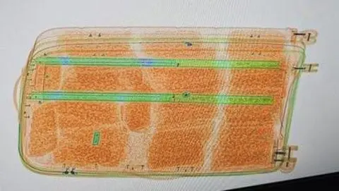 An Garda Síochána An image of a suitcase, the inside of which is bright orange. There are also two long bright green stripes at the top of the suitcase. 