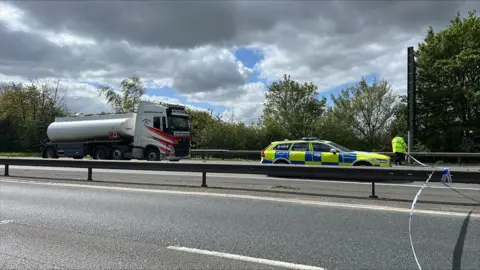 Richard Knights/BBC A lorry and a police car on the A12 northbound. There is a police officer and a police cordon put in place over the road